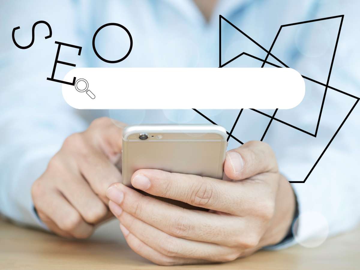 Close up hands holding silver mobile phone with white search box above the letters SEO and graphical geometric decoration top right