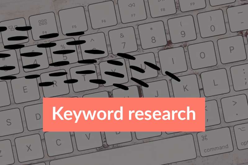 Text Keyword research on coral coloured background photo of keyboard with letters and numbers in background